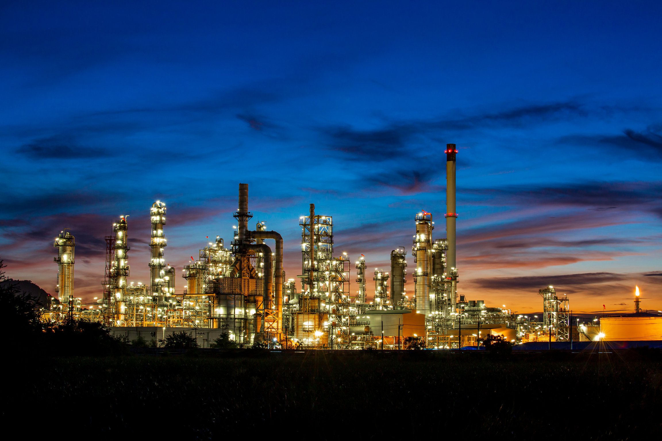 Twilight scene of tank oil refinery plant and tower column of Pe